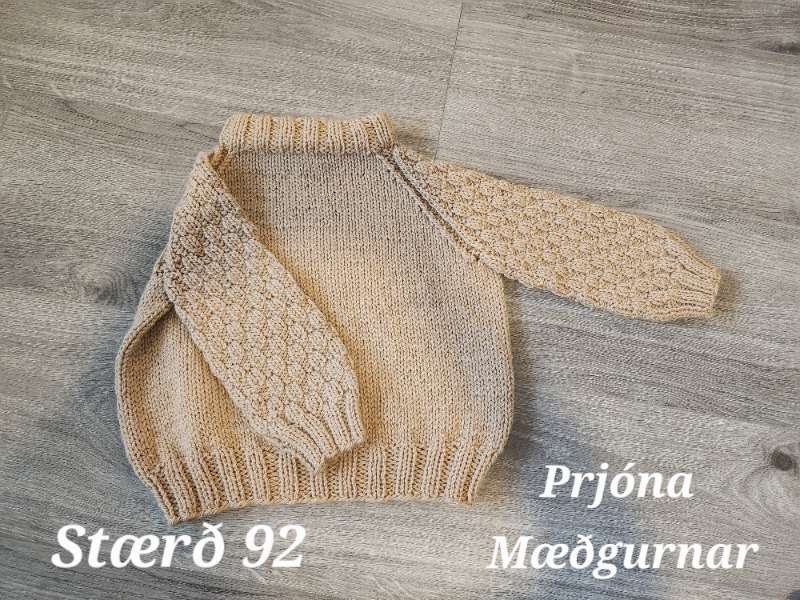 Ljósbrún með munstur á ermum