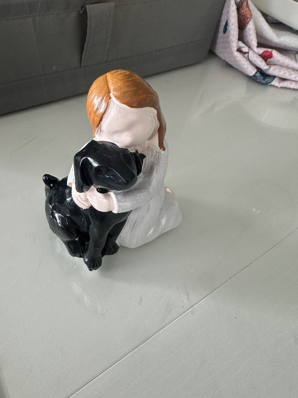 Stelpa að faðma hund svartan