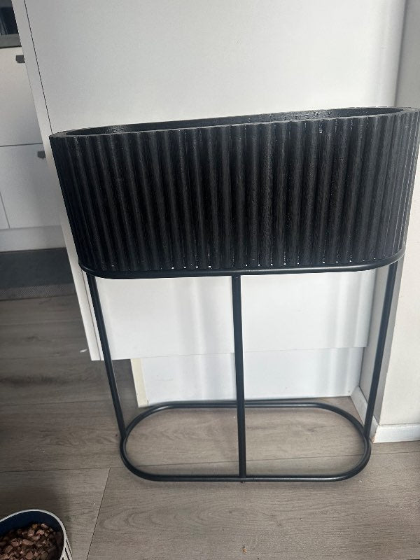 Stór svartur blómapottur á standi ónotað